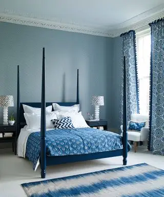 Ein komplett blaues Schlafzimmer mit blauem Himmelbett, Polstermöbeln, Vorhängen, Teppichen und Tapeten.