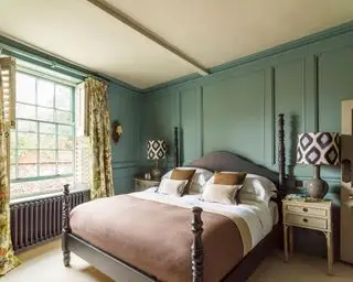 Ein grünes Zimmer mit Himmelbett, das luxuriöse Schlafzimmerideen veranschaulicht.