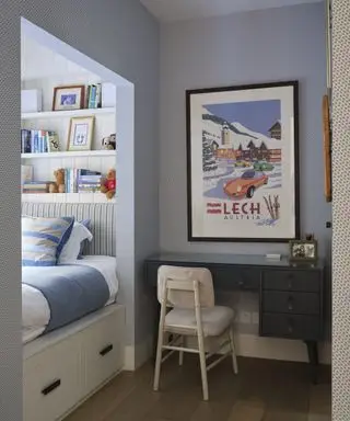 Ideas de dormitorio para niños con un rincón separado para la cama con estantes tipo alcoba, un escritorio negro y papel tapiz estampado en azul.