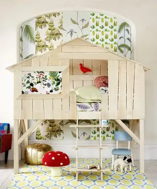 Ideas únicas para dormitorios para niños, con una cama en forma de casa en un árbol de madera y múltiples patrones diferentes de papel tapiz en verde y blanco.
