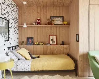 dormitorio de niños con colcha amarilla, traslapado, papel tapiz blanco y negro, estanterías y mesa auxiliar amarilla