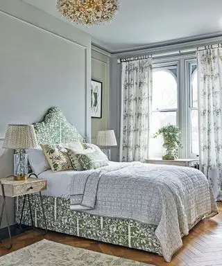 Quarto luxuoso com decoração de roupa de cama, luz de teto e cortinas