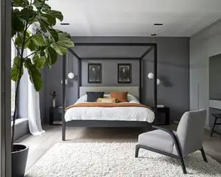 Ein Schlafzimmer mit dunkelgrauen Wänden und einem schwarzen, modernen Himmelbett