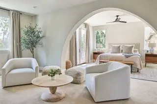 Camera da letto a pianta aperta e soggiorno con dettagli architettonici ad arco che separano i due