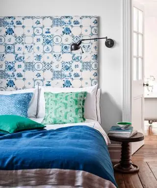 Un esempio di idee per la camera degli ospiti che mostra un letto blu con una testiera a motivi blu e bianchi