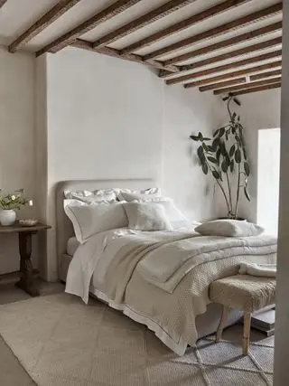 Camera da letto rilassante con biancheria da letto e plaid White Company