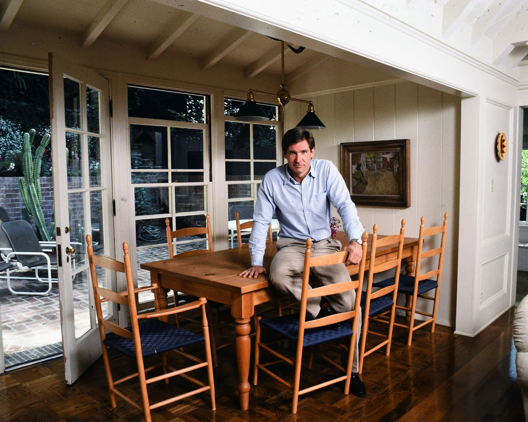 Harrison Ford con il suo tavolo e le sue sedie in legno' loading='lazy' title=