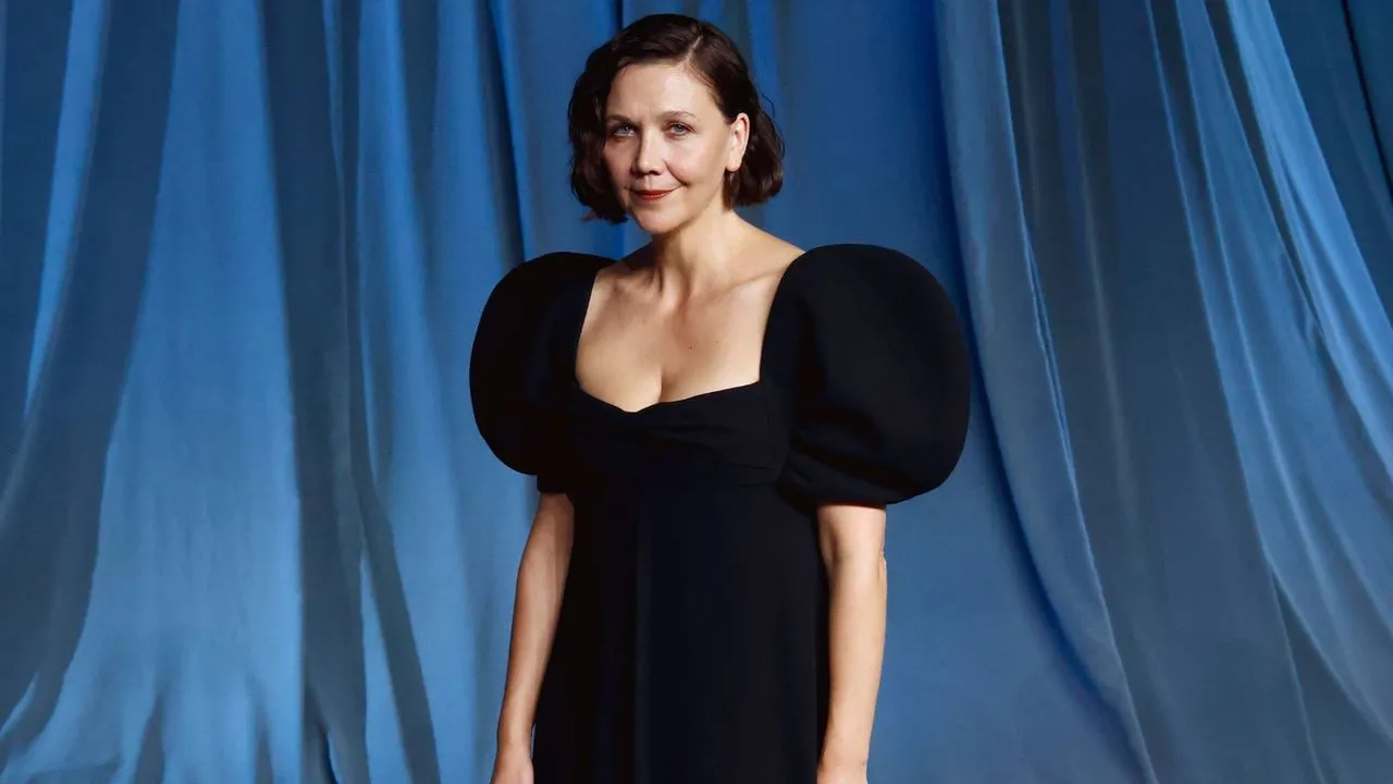 Maggie Gyllenhaal w czarnej aksamitnej sukience na tle niebieskich zasłon' loading='lazy' title=