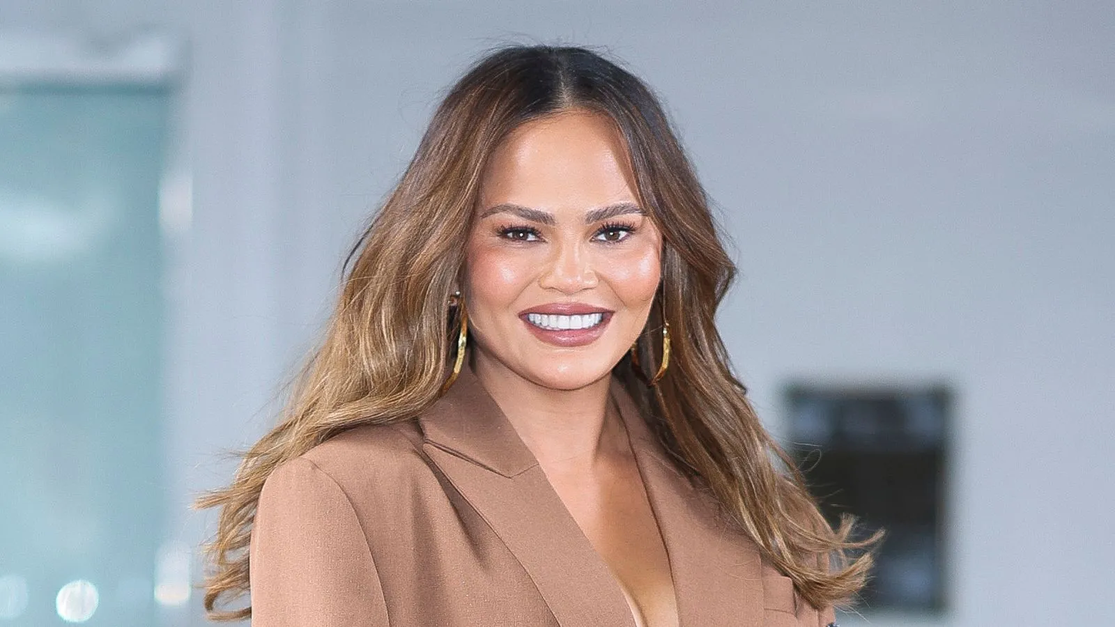 chrissy teigen på blå bakgrunn' loading='lazy' title=