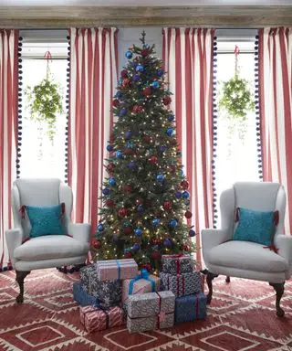 Weihnachtsfensterdekorationsideen mit einem Weihnachtsbaum, Doppelfenstern mit Kränzen in jedem und rotem und blauem Dekor