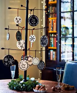 ぶら下がっているビスケットの飾り、底を囲む葉を持つ金属製のクリスマス ツリーの接写