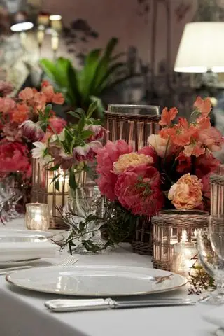 Mesa navideña con flores, velas y velas de té.