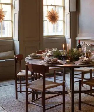 Acogedor comedor con adornos navideños, velas y follaje.