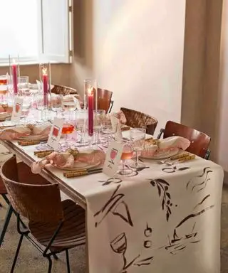 mesa larga para una celebración especial con una idea de mantel pintado a mano