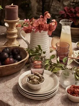 høstbordidé med keramikkmugge og blomster, bærglass, treskål, lysestake, off-white tallerkener, mørk rosa duk