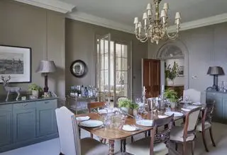 Graues Esszimmer mit Kronleuchter und farbigen Schränken