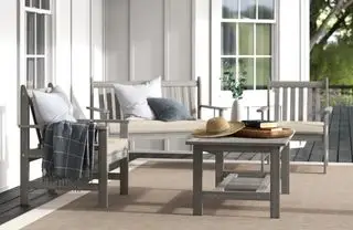 Un juego de asientos de madera al aire libre en madera lavada en gris.