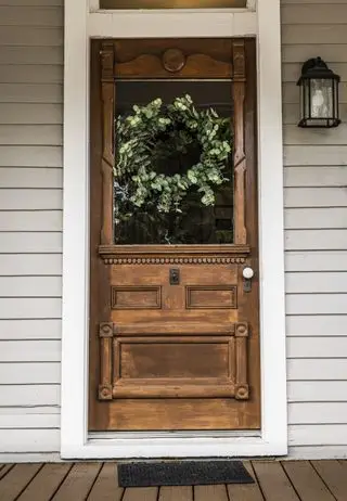 hermosa puerta de entrada antigua de madera con una corona de eucalipto
