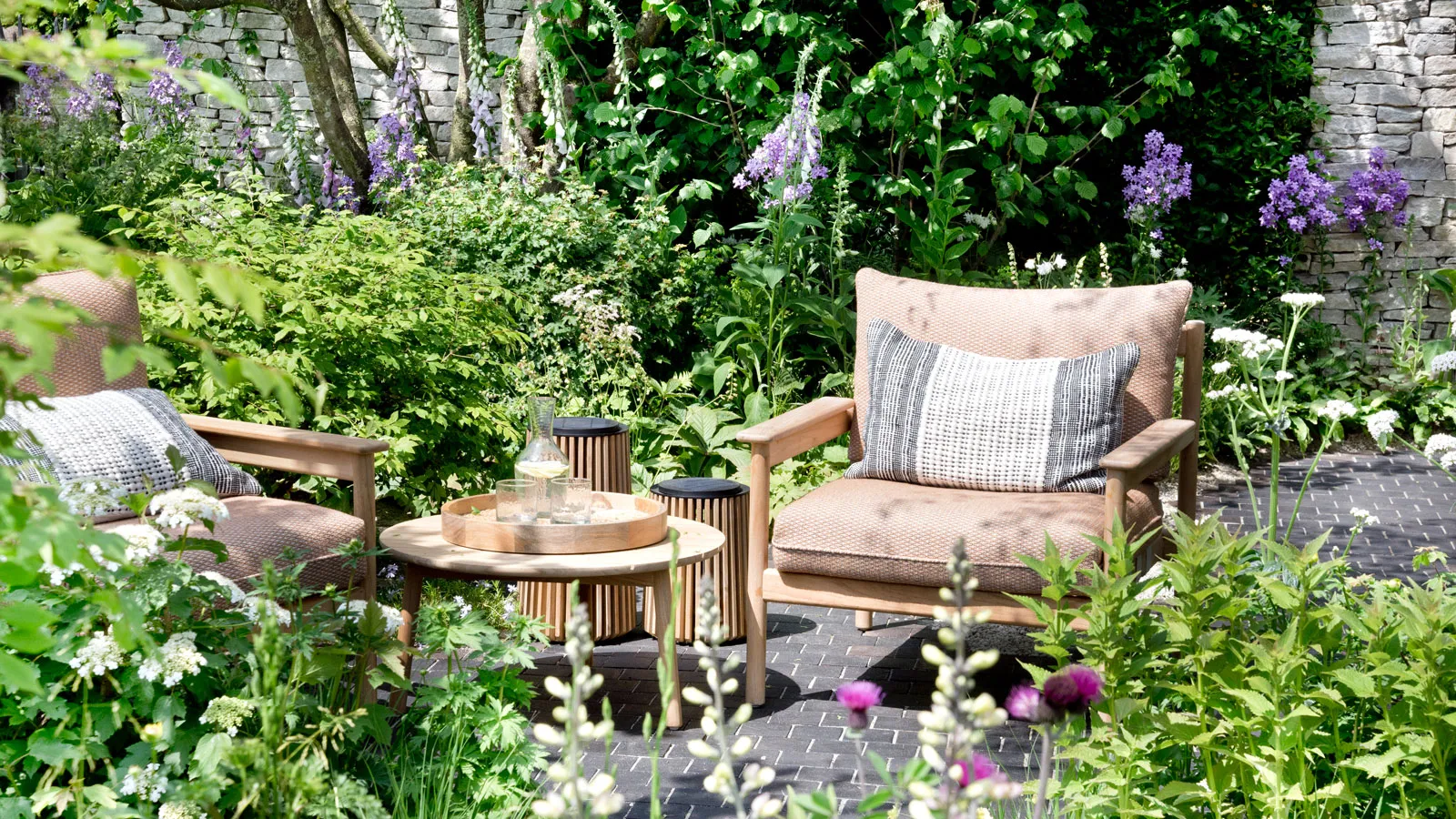 Jardin de cour avec table de sièges et fleurs' loading='lazy' title=