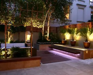 Patio con jardín pavimentado con terraza e iluminación