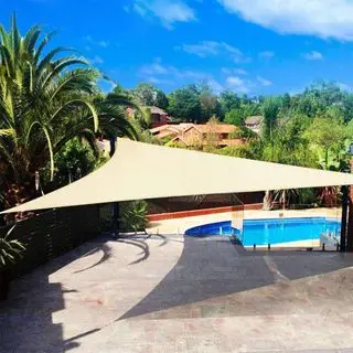 voile d'ombrage crème sur un patio donnant sur une piscine
