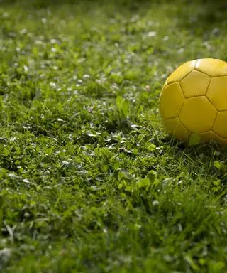 gul fotball på en plen
