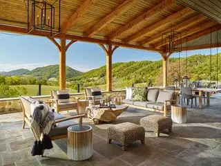 terrasse med træpergola og havelænestole og bord