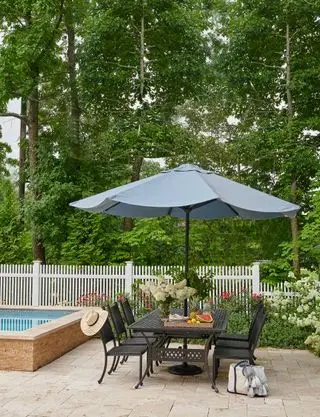 terrasse med udendørs bord og stole ved siden af ​​swimmingpoolen