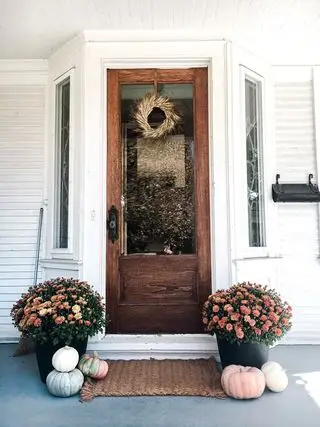 couronne de décoration de devant d'automne et jardinières de fleurs