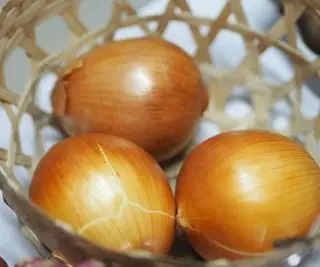 Tres cebollas marrones en un bol