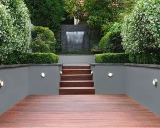 Garten auf zwei Ebenen mit überdachtem Bereich und Stufen mit integriertem Lichtdesign