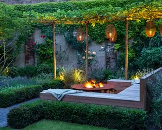 Gemütlicher Garten mit Gartenbeleuchtung, Hängelaternen und Feuerstelle