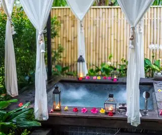 banheira de hidromassagem de inspiração tropical com cortinas de privacidade