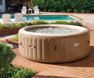 banheira de hidromassagem inflável em um pátio ao lado de uma piscina