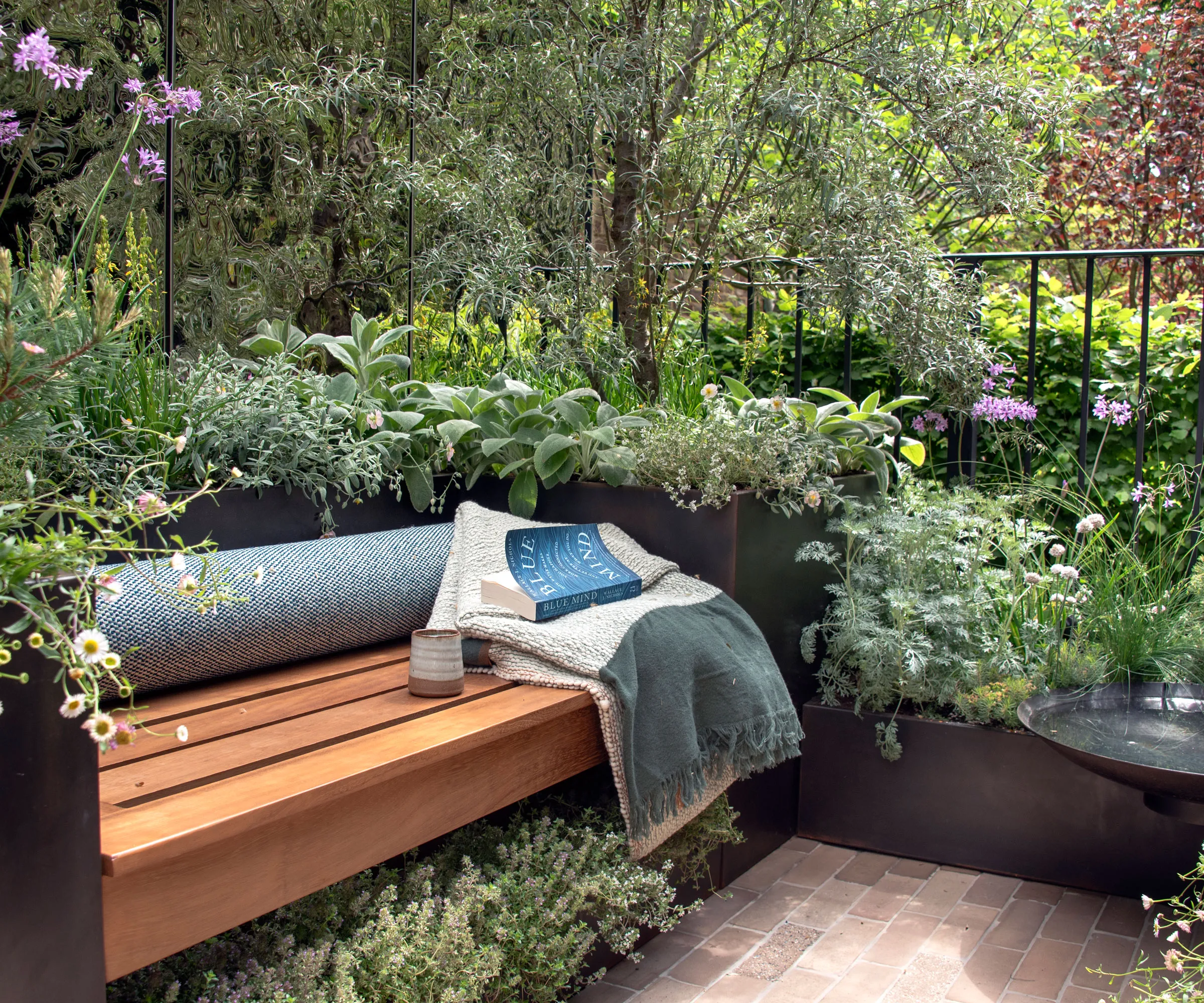 lille altanhave med bænkkast kaffekopbog og beplantning' loading='lazy' title=