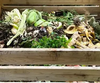 Un tas de compost en bois fait maison rempli de légumes et de déchets de jardin