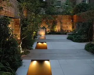 moderno pátio com jardim iluminado à noite