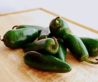 Piments jalapeno verts mûrs sur une planche de bois