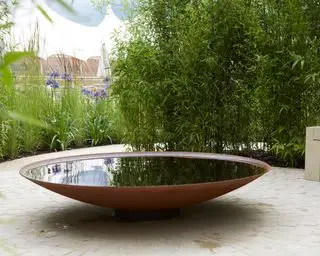 una fuente de agua en un tazón en un patio trasero