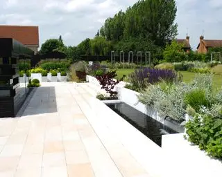 Design af en terrasse med et vandelement i et elegant, moderne haveskema.