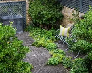 Design af en gårdhave i overensstemmelse med omgivende arkitektur, demonstreret med sildebensgulv i mørke mursten i et industrielt inspireret skema.