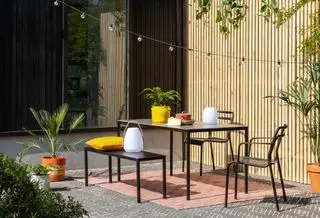 Ideen für Terrassenmöbel aus schwarzem Metall in Kombination mit Holzlattenzäunen und Lichterketten.