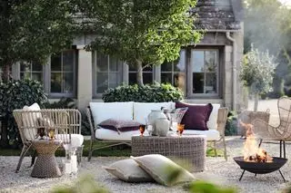 Nicht übereinstimmende Ideen für Outdoor-Terrassenmöbel aus Korbgeflecht mit einer Feuerstelle in einer Kiesterrasse im Landhausstil.