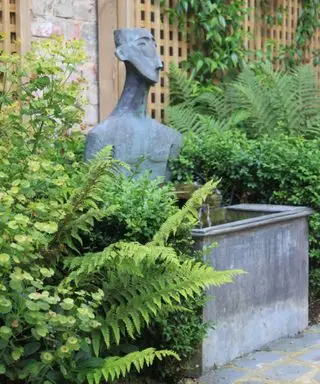 escultura de jardín de metal y fuente de agua