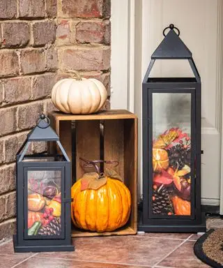 Idéias para decoração de portas de Halloween com lanternas pretas cheias de folhas de outono e abóboras em miniatura