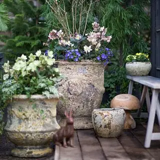 plantekasser med blomster på en mursteinsterrasse