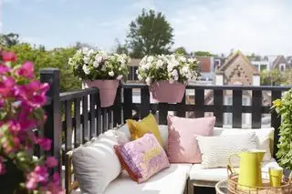 Balcone con divano ad angolo e ringhiera con fioriere