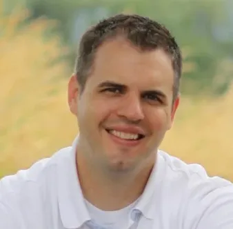 Expertenfoto eines Mannes mit kurzgeschnittenem Haar und weißem Hemd.' loading='lazy' title=