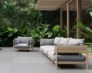 En japansk-inspireret udendørs sofa og loungestol i teaktræ ved siden af ​​en tropisk pool