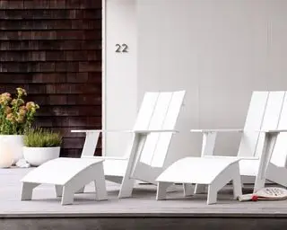 Et par hvide HDPE Adirondack stole på en moderne veranda